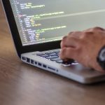 A person writing lines of code on a laptop