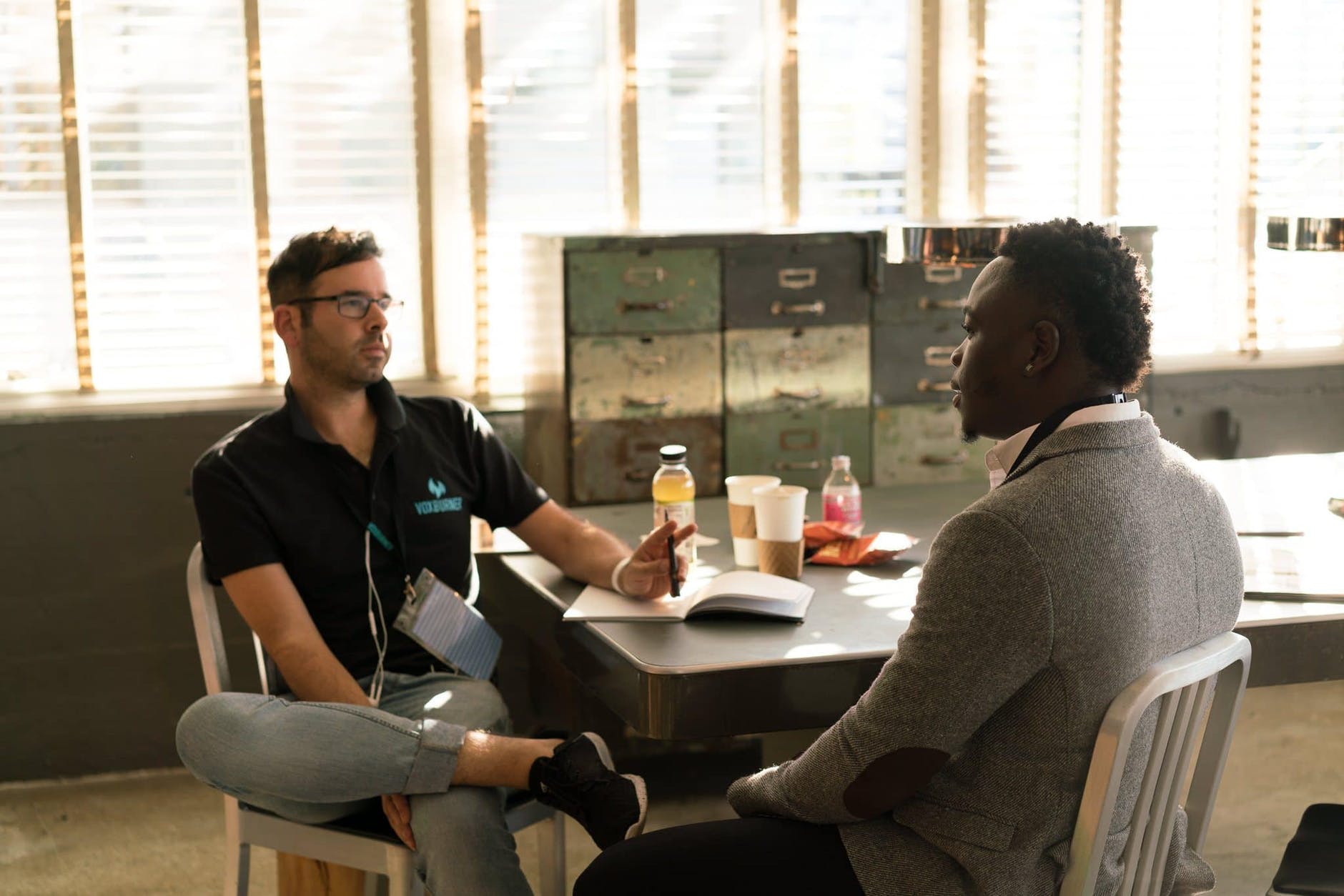 Two men sitting in chairs, talking