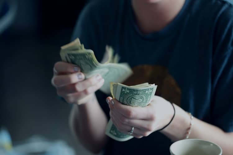 a woman counting dollar bills.