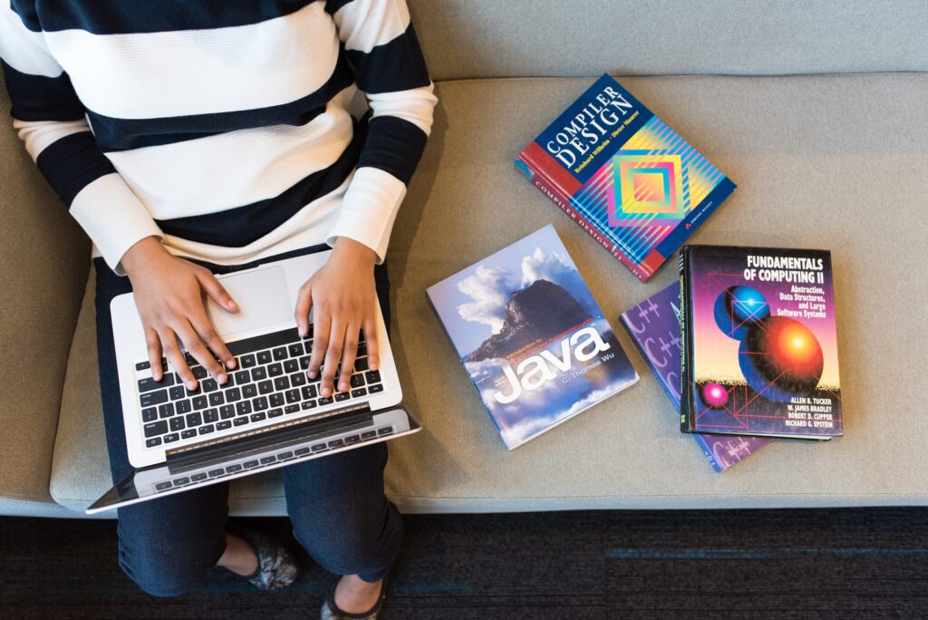 a person working with programming books at the side