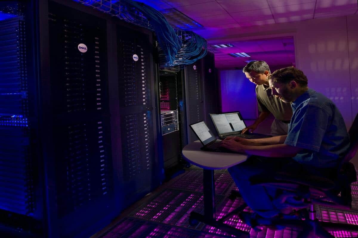 two men working on supercomputers