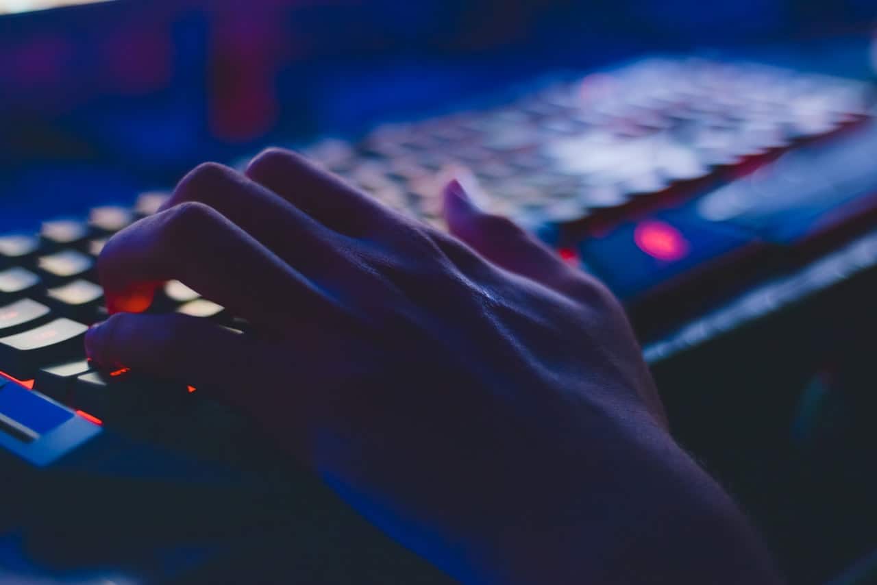 hands typing on backlit keyboard