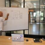 a man drawing and explaining UI design on whiteboard