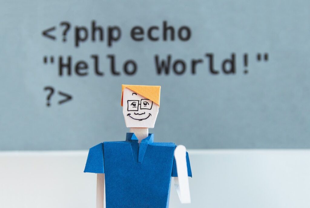 cardboard cutout of a man in front of PHP code Hello World