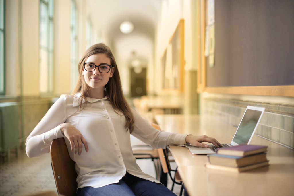 a woman in a white long-sleeved shirt sitting at a desk with a computer