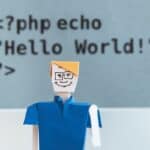 A doll stands in front of a board displaying PHP code. Types of Coding Languages