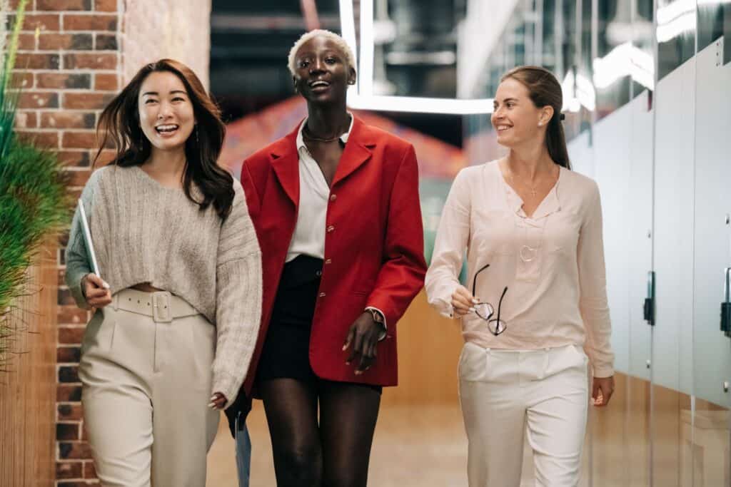 Three people walking down an office hallway smiling guide to setting career goals