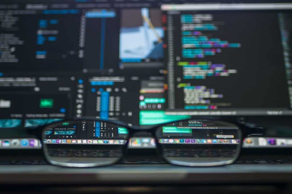 A pair of glasses in front of a computer displaying code scholarships for computer science