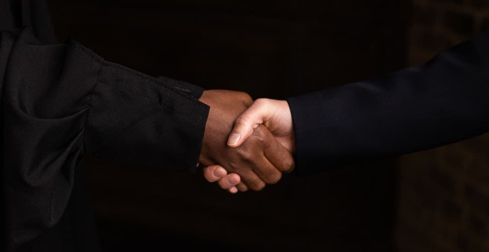 Two men shaking hands in an enclosed office space. How to Get a Job at Lockheed Martin