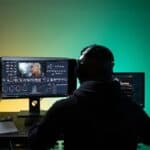 A quantum computing software engineer wearing a headset and working with developer tools on a computer monitor.