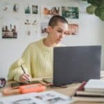 A woman working on laptop and using drawing tablet